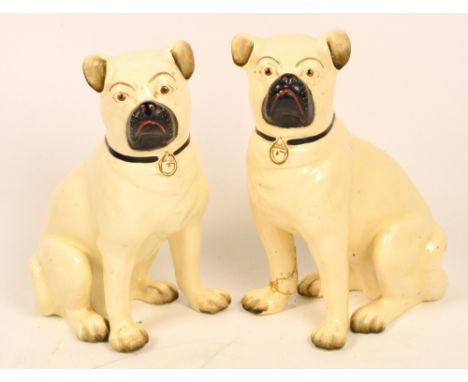 A pair of late Victorian ceramic pugs, height 29cm (af). CONDITION REPORT: Both pugs are damaged. The left hand pug has a cra