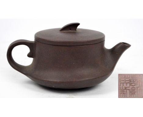 An early 20th century Chinese Yixing circular teapot, impressed seal mark to base and underside of lid, length 12.5cm. CONDIT