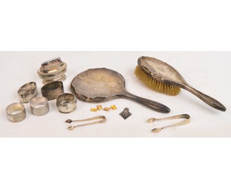 A mixed lot including a silver backed hand mirror and brush, napkin rings, table lighter etc.