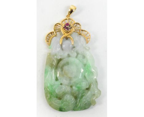 An early 20th century Chinese jadeite pendant carved and pierced as a confronting dragon and phoenix around a central auspici