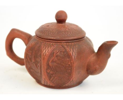 A Chinese Yixing lobed teapot decorated in relief with roe deer, bats, bird and heron, unmarked, length 14cm.