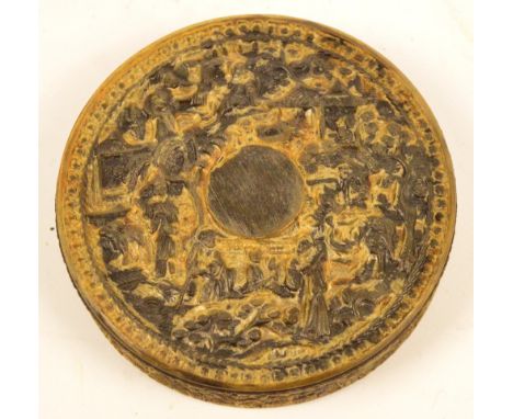 An early 19th century Chinese Export buffalo horn circular snuff box, carved throughout with figures in a village landscape, 
