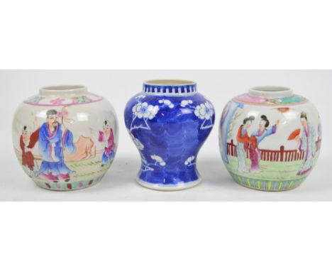 A pair of early 20th century Chinese porcelain jars painted in Famille Rose enamels with figures in a fenced garden landscape