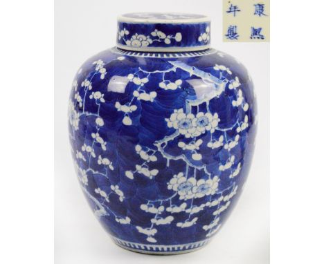 A large 19th century Chinese porcelain jar and cover, painted in underglaze blue with blossoming prunus on a blue ground, bea