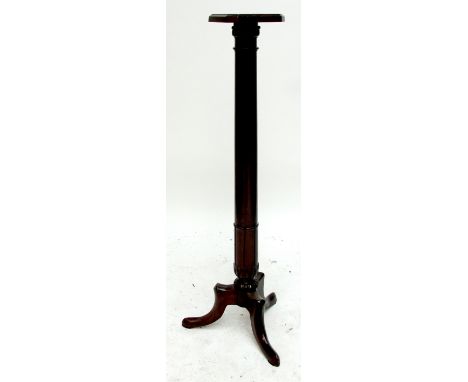 A mahogany torchere, the canted square top on turned column and tripod supports.