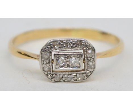 An Art Deco yellow metal diamond ring with squared two stone inset surrounded by ten small stones, size S.