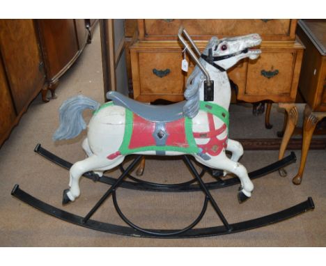 A vintage carousel horse, now mounted as a rocking horse on a contemporary wrought iron frame.
