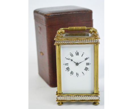 An early 20th century French brass cased carriage clock with shaped case and square enamel dial set with Roman numerals, heig