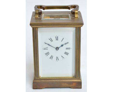 An early 20th century French brass cased rectangular carriage clock, the rectangular white enamel dial set with Roman numeral