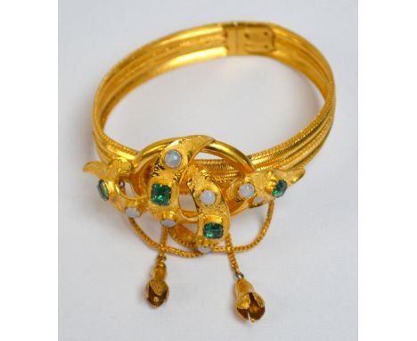 A yellow metal bracelet set with four emeralds and six opals within a raised interwoven knot design, approx 20g. CONDITION RE