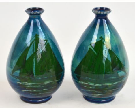 A pair of ceramic ovoid vases with a decoration of green yachts on a sea and sky blue ground, with beaded rims and raised on 