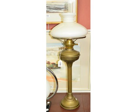 A brass oil lamp with fluted central column and opaque shade.