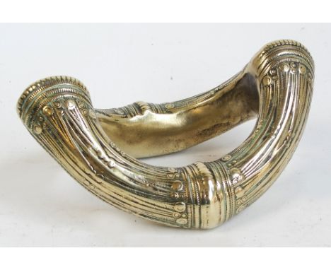 A heavy polished brass slave bangle with raised detailing, length 15.5cm.