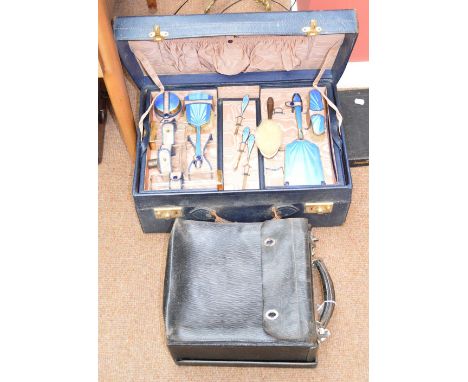 An Art Deco lady's travelling vanity suitcase with lift-out tray enclosing various glass bottles, hand brushes, nail implemen