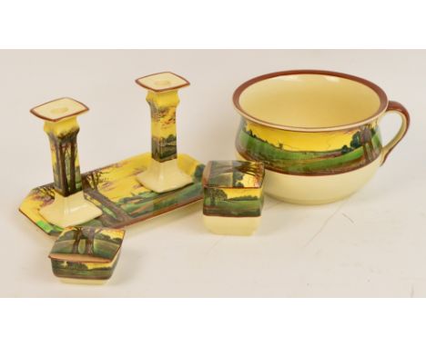 A Royal Doulton dressing table set decorated with trees and landscape with cottages, comprising two lidded jars, pair of cand