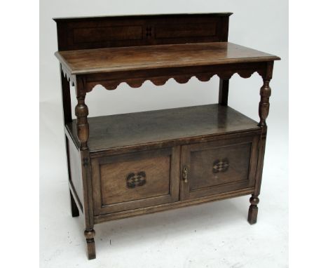 An early 20th century mahogany buffet, with inlaid rectangular back above shaped apron and turned supports above pair of cupb