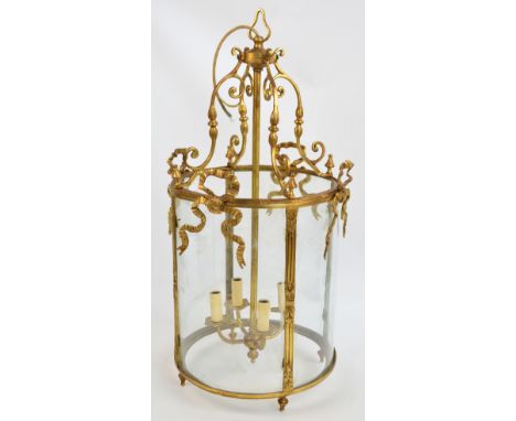 A gilt metal cylindrical ceiling light with scroll and ribbon decoration, height 84cm.