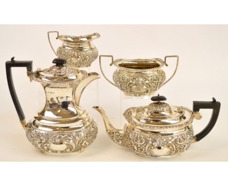 An Edward VIII and George V hallmarked silver matched four piece tea service with ornate repoussé floral and foliate decorati