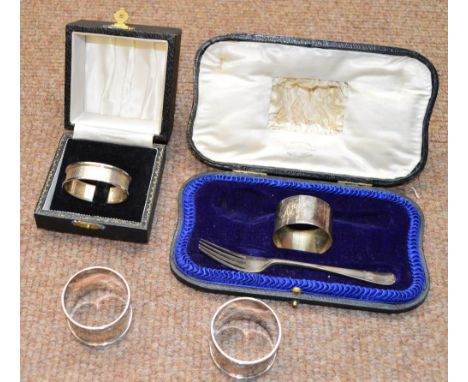 A pair of George V hallmarked silver napkin rings, Chester 1914, a further silver napkin ring and a cased silver napkin ring 