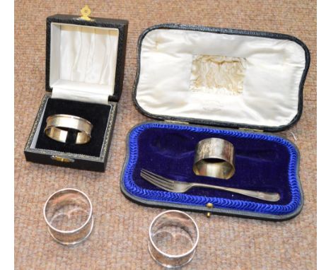 A pair of George V hallmarked silver napkin rings, Chester 1914, a further silver napkin ring and a cased silver napkin ring 