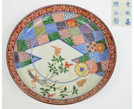 An early 20th century Japanese shallow bowl for the Chinese market painted in the Kakiemon palette, with floral sprays and a 