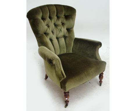 A Victorian green button upholstered armchair.