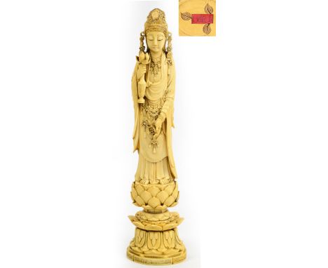 A finely carved 19th century Chinese ivory figure of Guanyin wearing an elaborate headdress and holding a vase containing a l