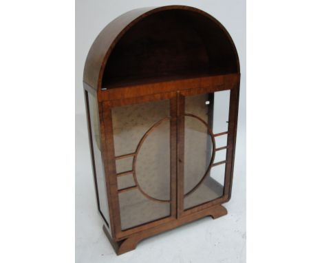 An early 20th century Art Deco mahogany display cabinet with domed top over a shelf, and hinged glazed sun pattern doors encl