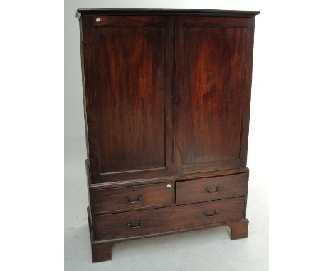 A George III mahogany linen press, the upper section with twin doors enclosing four slides above a base of two short and one 