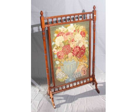 Late Victorian walnut firescreen with needlework vase of flowers panel, 126cm by 75cm.