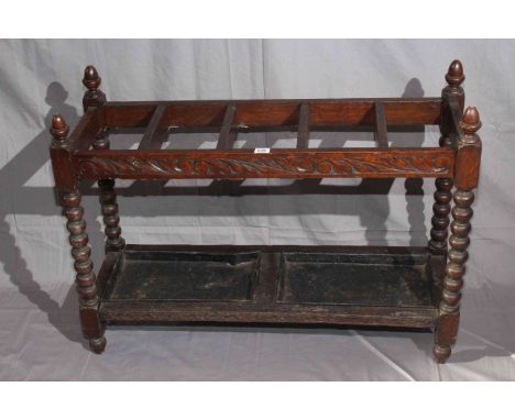 Carved oak bobbin leg five division stick stand, 68cm by 92cm.