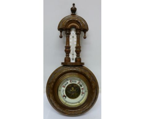 A carved walnut aneroid barometer and thermometer