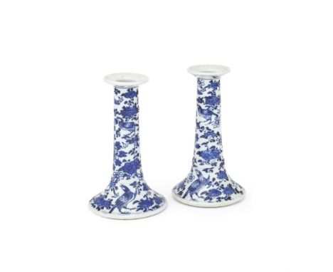A PAIR OF CHINESE BLUE AND WHITE CANDLESTICK HOLDERS 18TH CENTURY Painted to the exterior in cobalt tunes with birds and flow