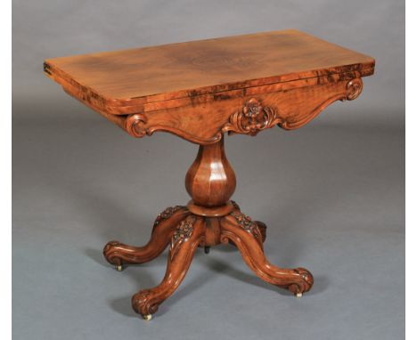 A VICTORIAN WALNUT QUARTER-VENEERED CARD TABLE having a fold-over top, the interior lined with circular baise, swept apron wi