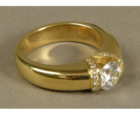 A GENTLEMAN'S RING SET TO THE CENTRE WITH A CIRCULAR FACETED CUBIC ZIRCONIA, flanked by further small circular faceted cubic 