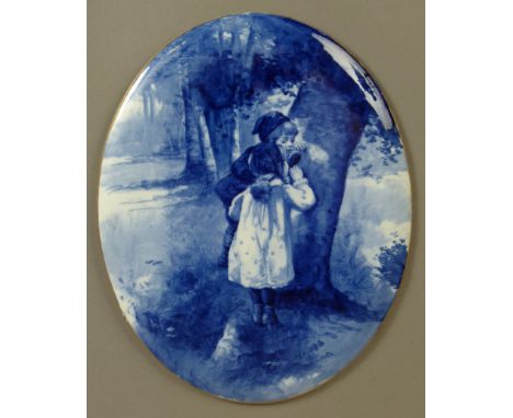 A DOULTON BURSLEM FLOW BLUE WALL PLAQUE, oval, painted with two children peering into a hole in the trunk of a tree, gilt rim