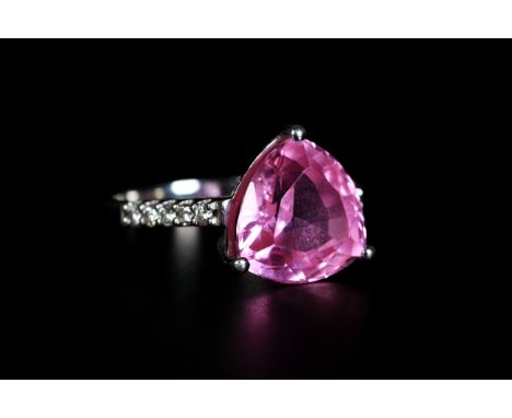 A PINK SAPPHIRE AND DIAMOND RING, in 18ct white gold, the rounded triangular pink sapphire claw set and raised against brilli