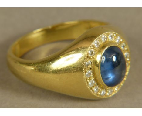 A SAPPHIRE, DIAMOND AND CUBIC ZIRCONIA CLUSTER RING collet set to the centre with an oval cabochon sapphire raised against a 