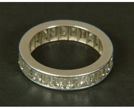 A DIAMOND ETERNITY RING, c.1960, the baguette cut stones channel set in platinum, finger size N?, total approximate weight of