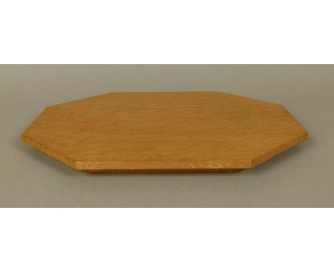 THOMPSON OF KILBURN 'MOUSEMAN' AN OAK BREAD BOARD of irregular octagonal outline, carved in relief with a mouse, 30.5cm x 25c