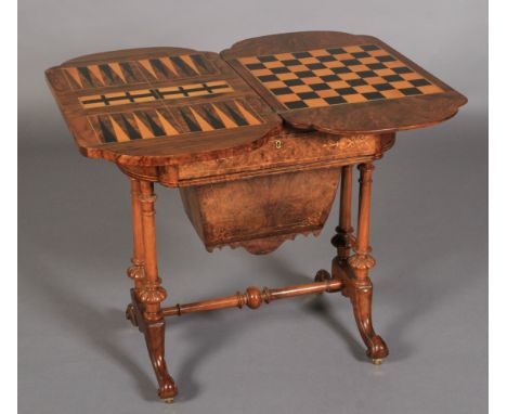 A VICTORIAN FIGURED WALNUT GAMES AND WORK TABLE, the fold-over swivel top of rectangular outline with bowed ends, inlaid to t