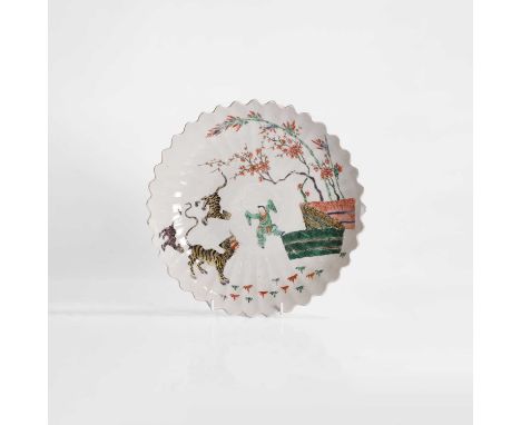 A Chinese famille verte plate, Kangxi (1662-1722), in the shape of a chrysanthemum, painted with a man at play with three tig