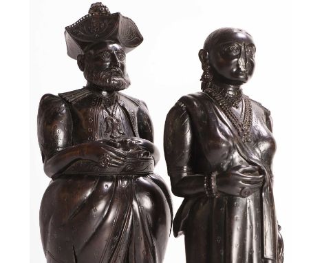 Two Anglo-Indian or Dutch colonial ebony figures, 19th century, each modelled standing and in draped, layered garments and je