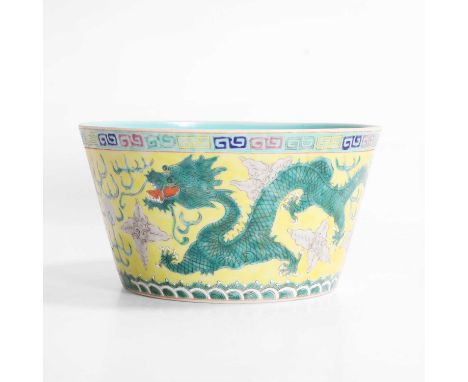 A Chinese sancai-glazed bowl, 20th century, painted with two dragons in green chasing a flaming pearl against a yellow ground