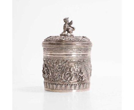 A Burmese white-metal container and cover, 19th century, repoussé decorated with traditional scenes and foliage, the cover wi