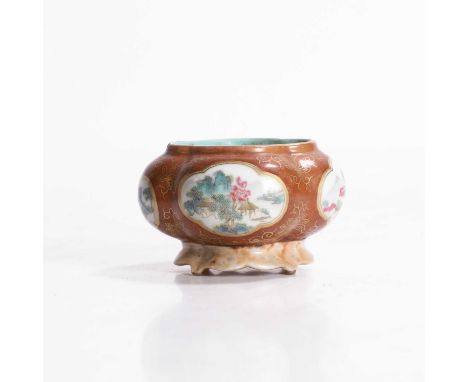A Chinese famille rose water pot, of lobed form on a faux marble stand, painted with landscapes in shaped panels, surrounded 