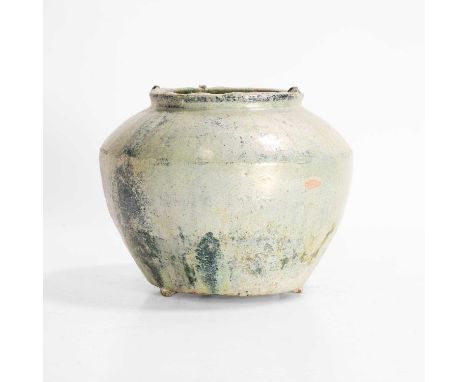 A Chinese lead-glazed jar, Han dynasty or later, of tapering form on three bracket feet, covered with a green lead glaze over