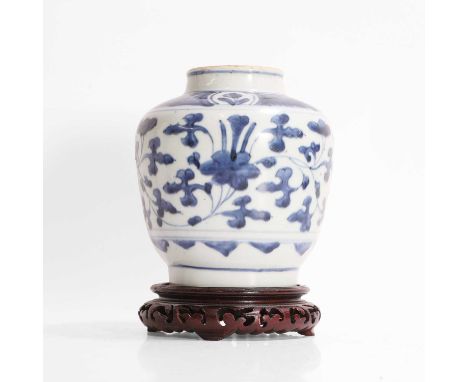 A Chinese blue and white jar, late Ming dynasty, of ovoid form, painted with scrolling flowers, 16.5cm high, associated wood 