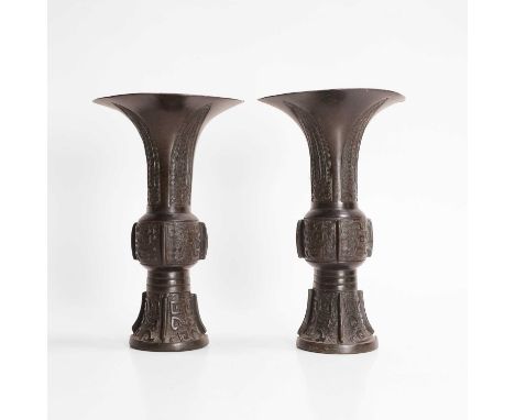 A pair of Japanese bronze wall vases, 19th/20th century, each in the shape of a gu vase with a flattened back, moulded with a
