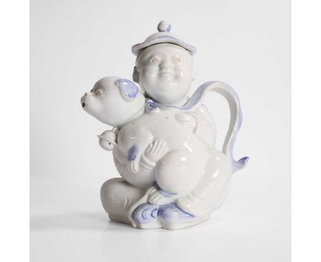 A Japanese Hirado teapot, Meiji period (1868-1912), modelled as a seated boy, wearing a robe painted with clouds and holding 